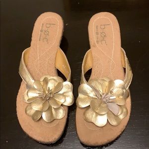 Gold sandals with a beautiful flower bow.